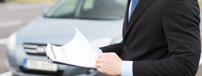 man with car documents outside